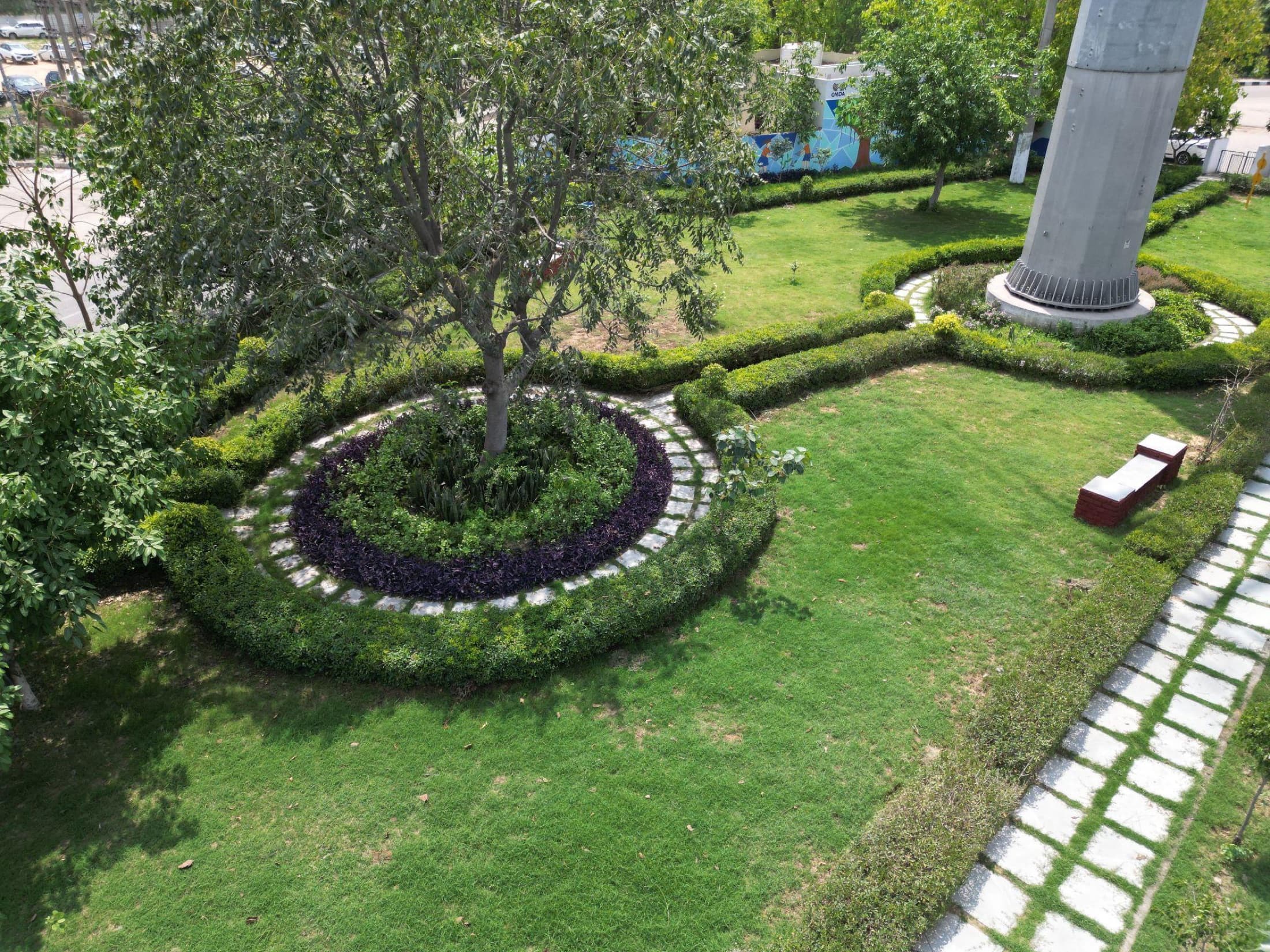 Aerial view of the landscaped garden with circular hedge beds, a walking path and seating