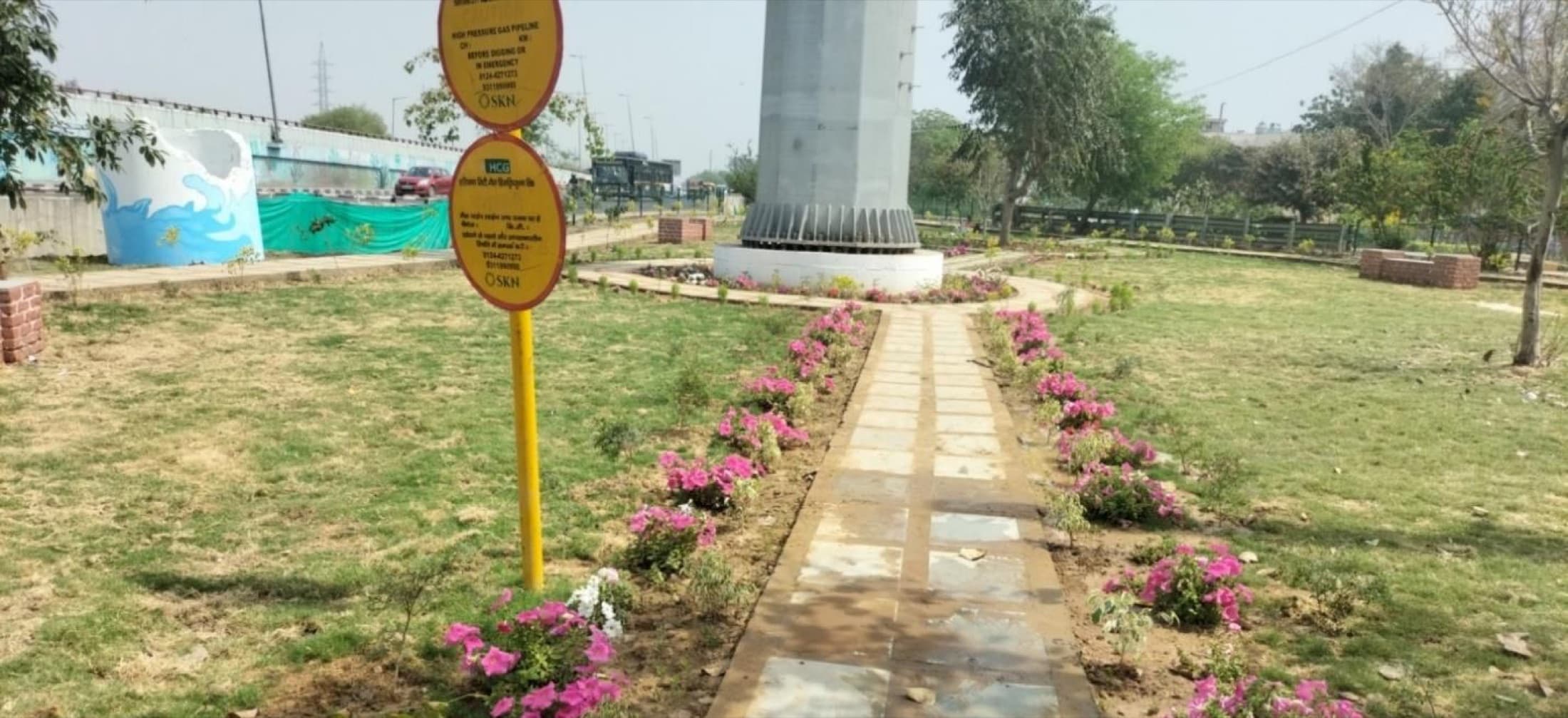 Ground view of the central pathway through the green belt, lined with flowering plants
