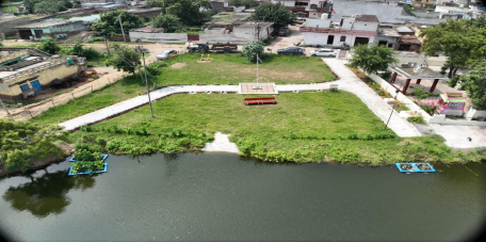 Aerial view of Mankrola Pond after interventions, 23 September 2025 — landscaped waterfront with seating and floating wetlands