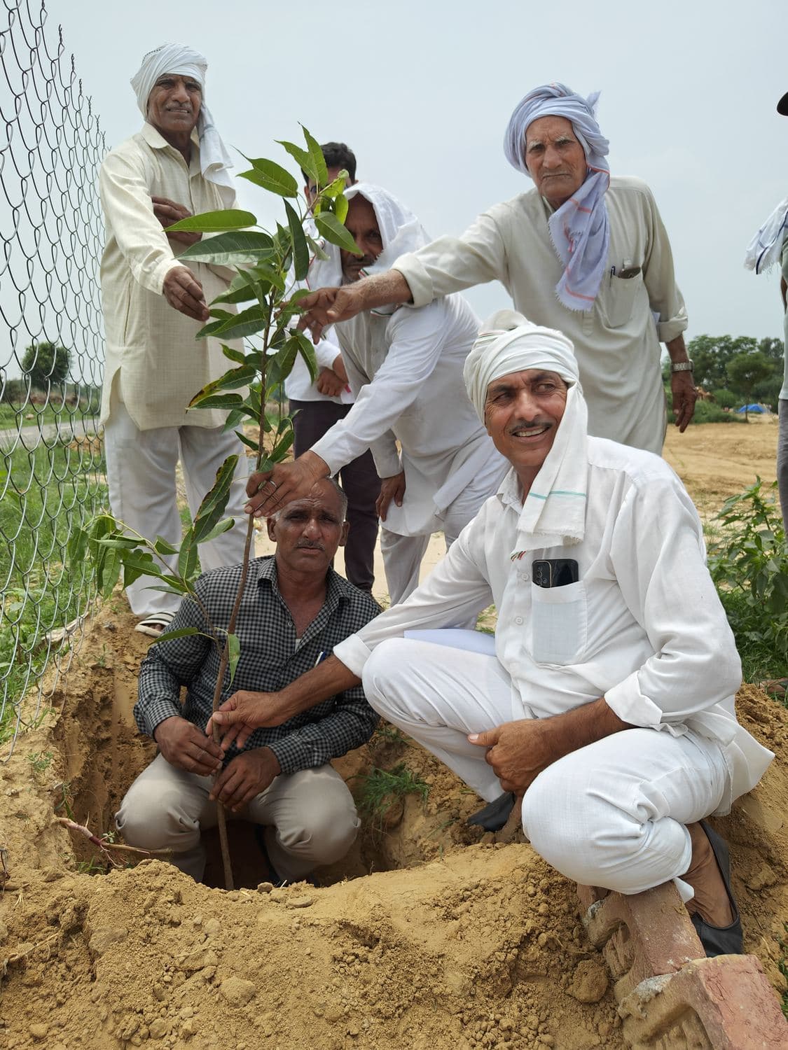 Community members and officials planting a tree at Triveni Pond